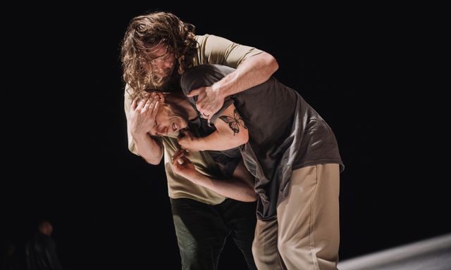 Man holding another scared man tight in his arms