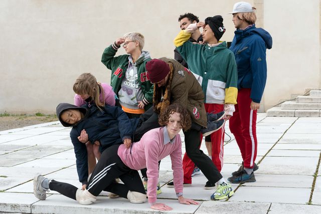 Diverse Gruppe von acht Personen, die zusammen posieren und sich stützen