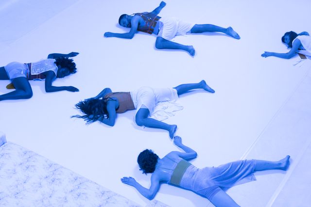 Group of performers lying on the floor