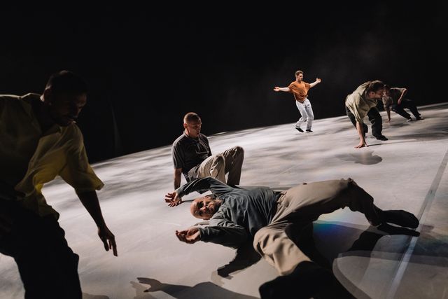 Group of male performers on stage, everyone dancing on their own