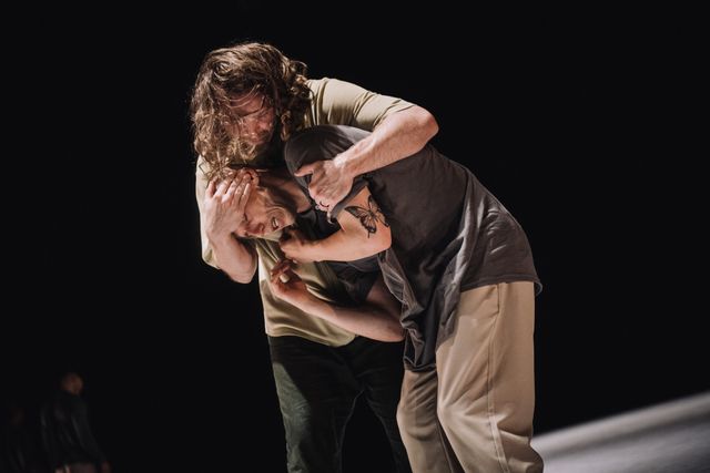 Man holding another scared man tight in his arms